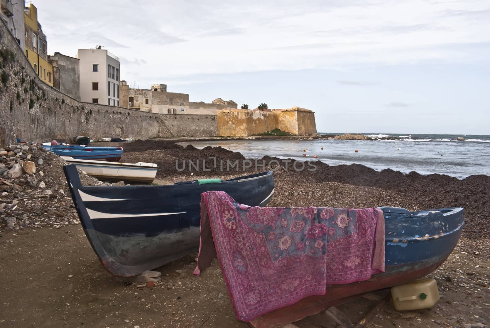 Boats in the marina of trapani with old buildings and sky cloudy