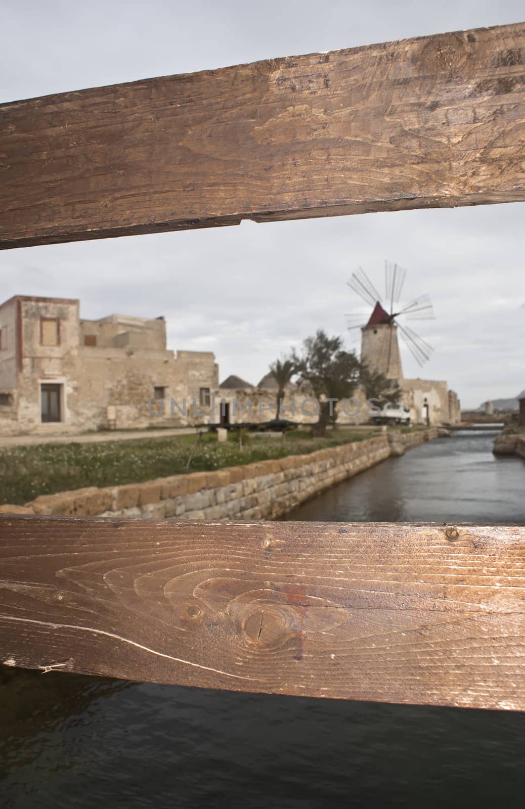 old mill seen from behind the fence. Trapani- Sicily