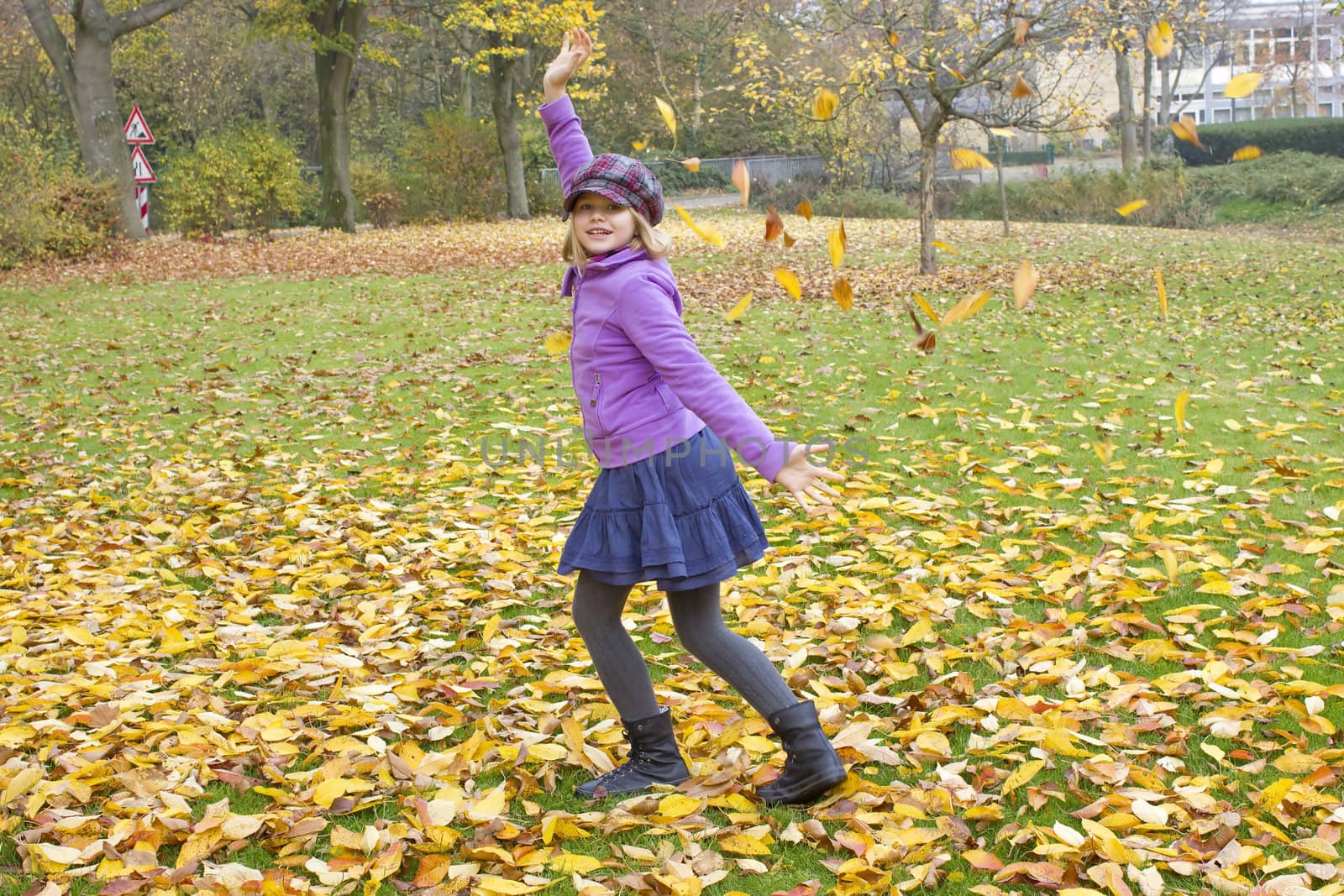 little girl plays with autumn leaves  by miradrozdowski