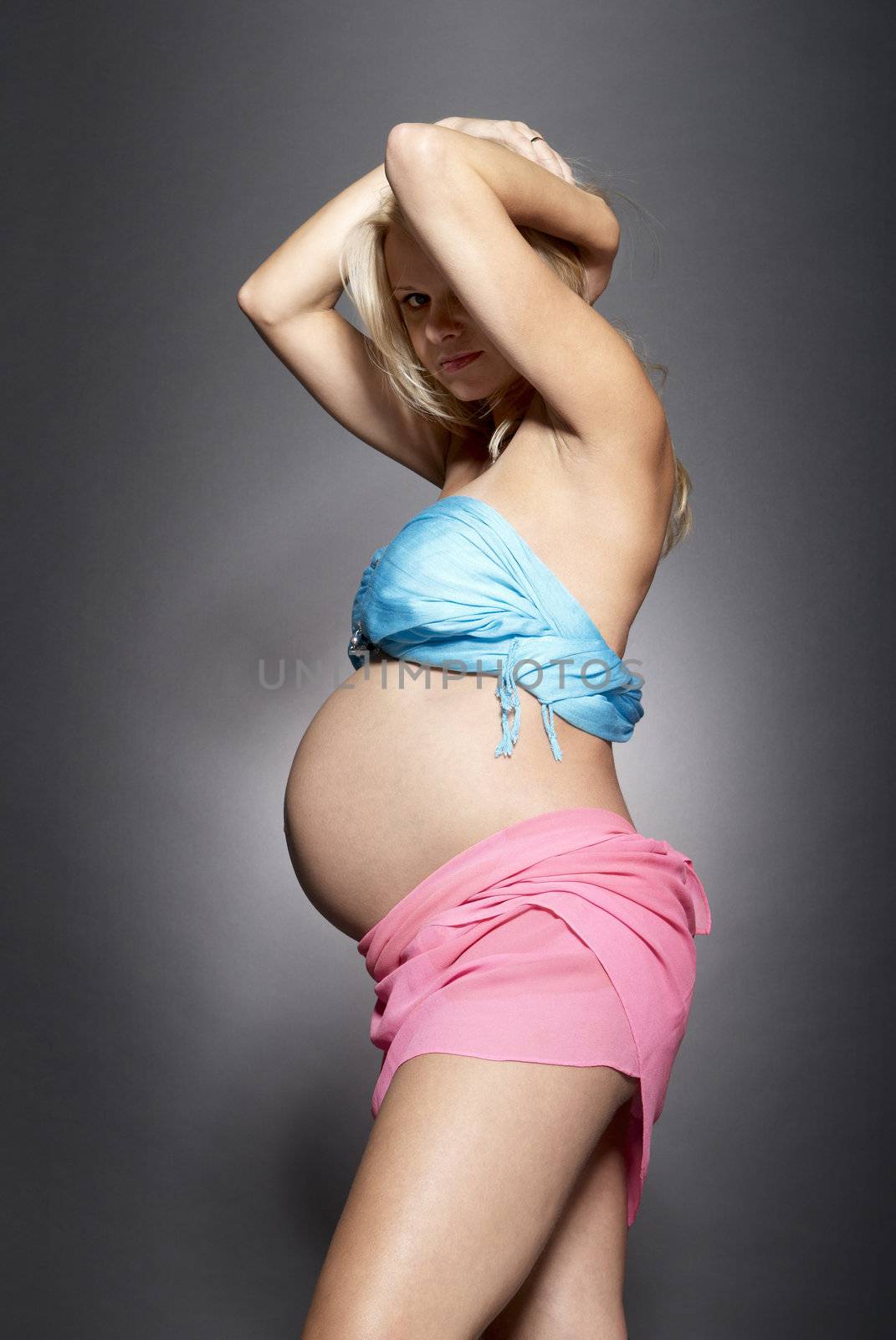 Portrait of a pregnant woman.  Studio photo of pregnant woman on gray background.