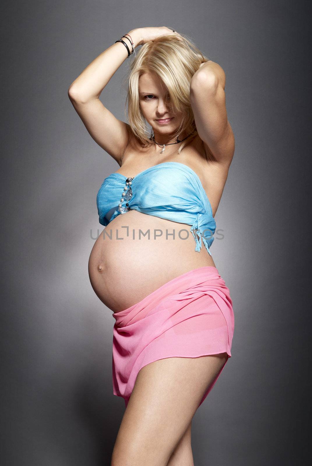 Portrait of a pregnant woman.  Studio photo of pregnant woman on gray background.