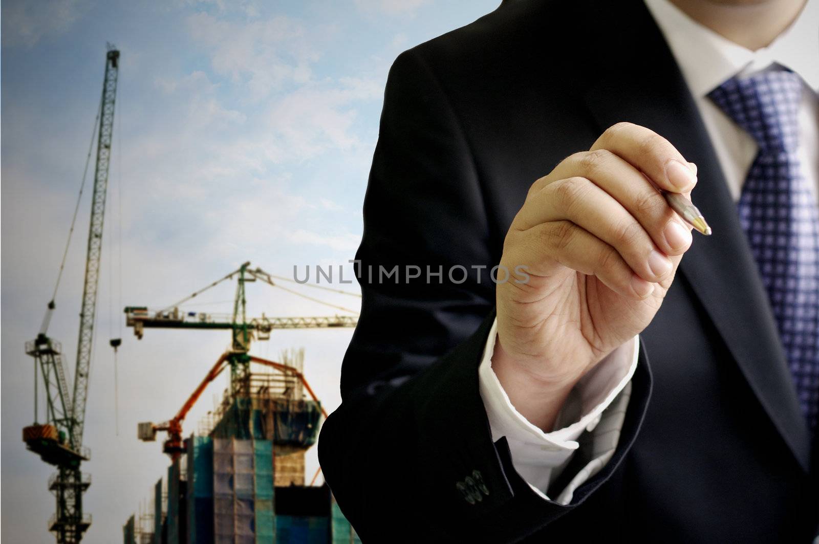 Businessman write on the air with construction site background by pixbox77