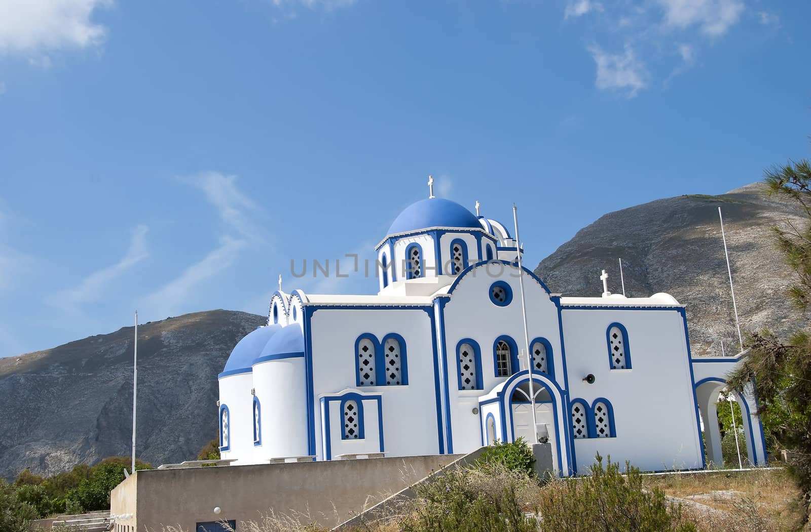 A Modern Blue Domed Greek Orthodox Church with a Mountain Background