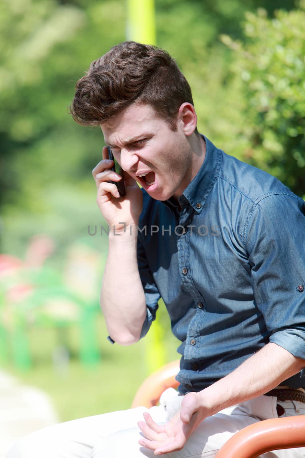 Young man angry and shouting on telephone
