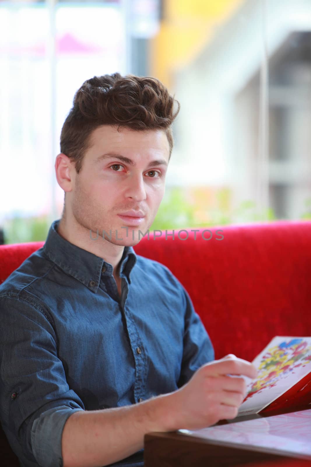 Young handsome man ordering in restaurant