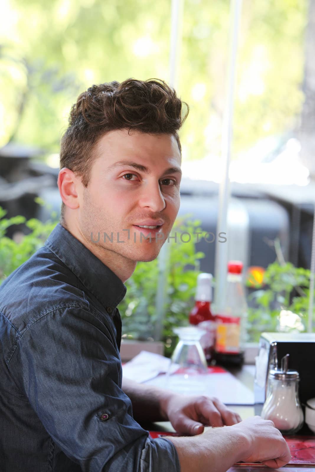 Young single man in restaurant waiting to be served