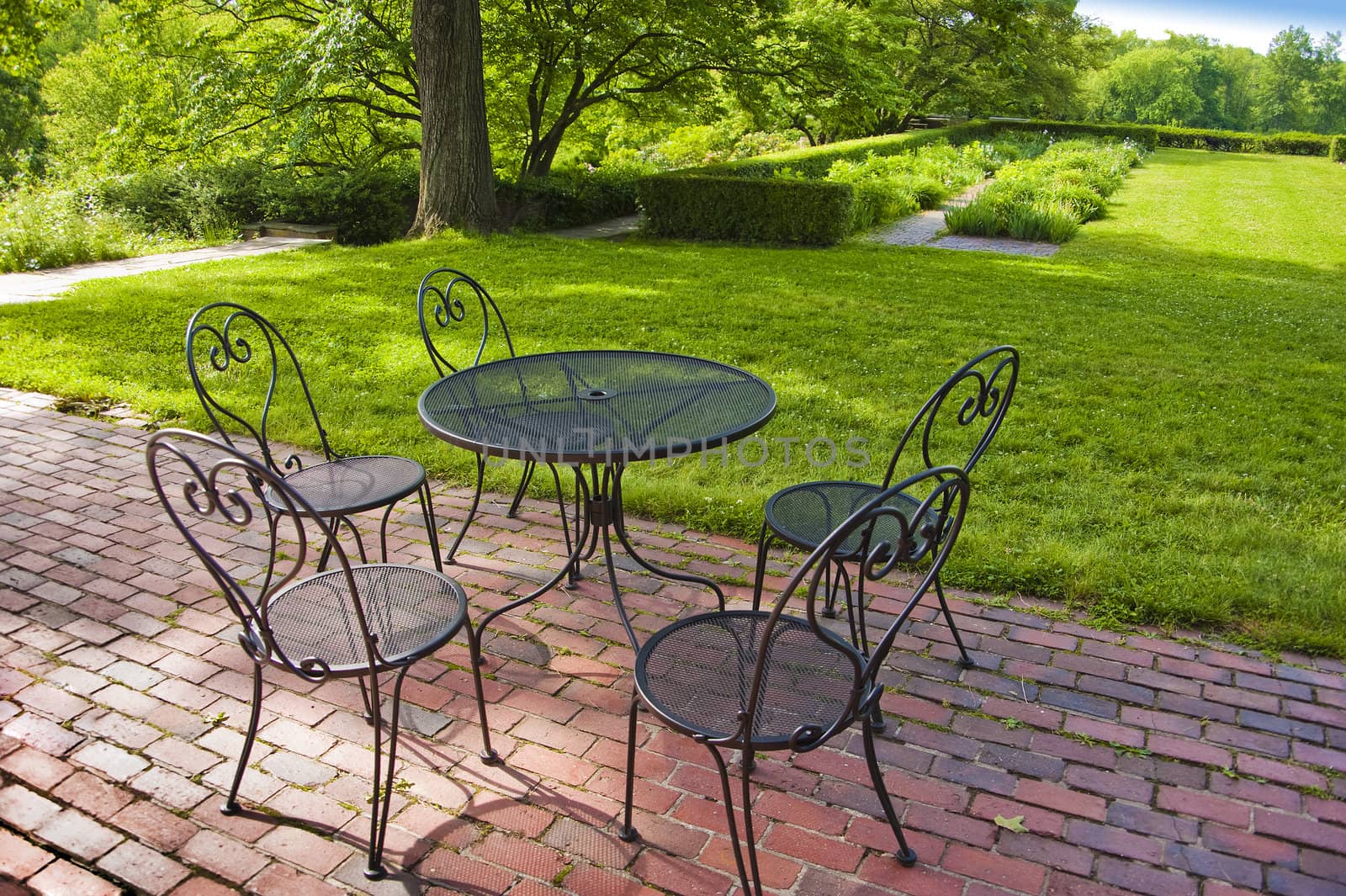 Patio chairs and table overlooking a garden