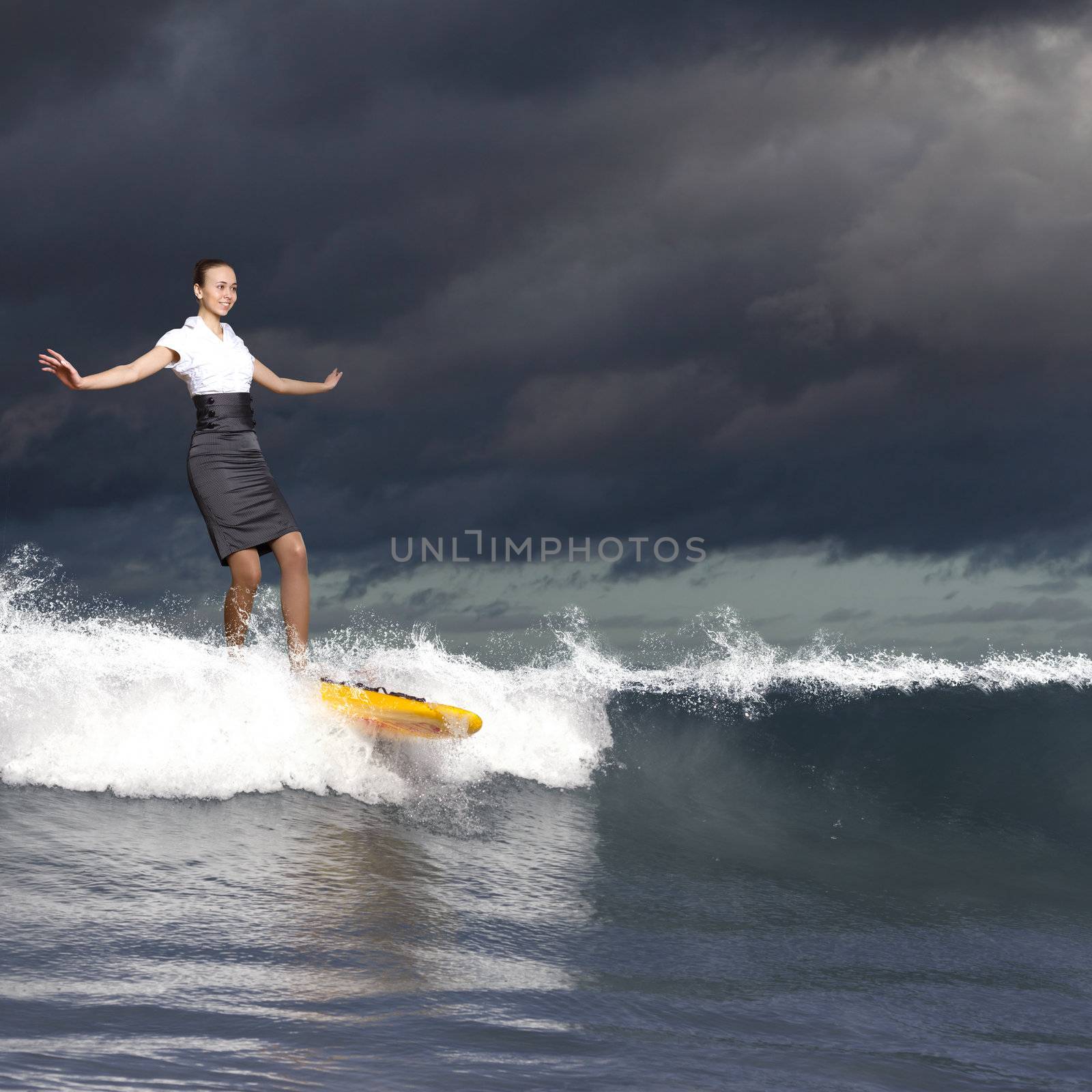 Image of young business person surfing on the waves of the ocean