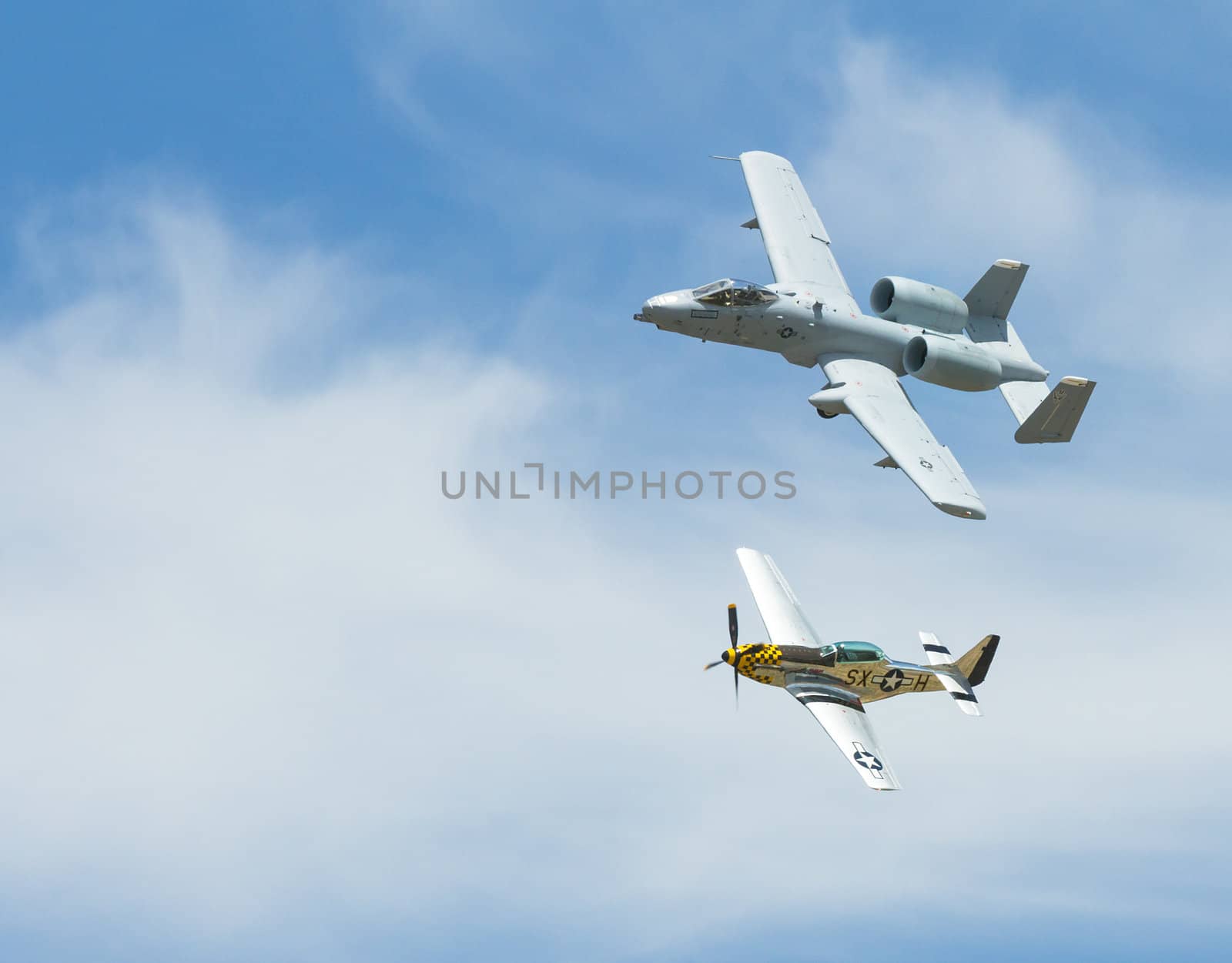 The Modern tank buster a A-10 warthog in a heritage flight with the WWII great the P-51 mustang both banked in flight