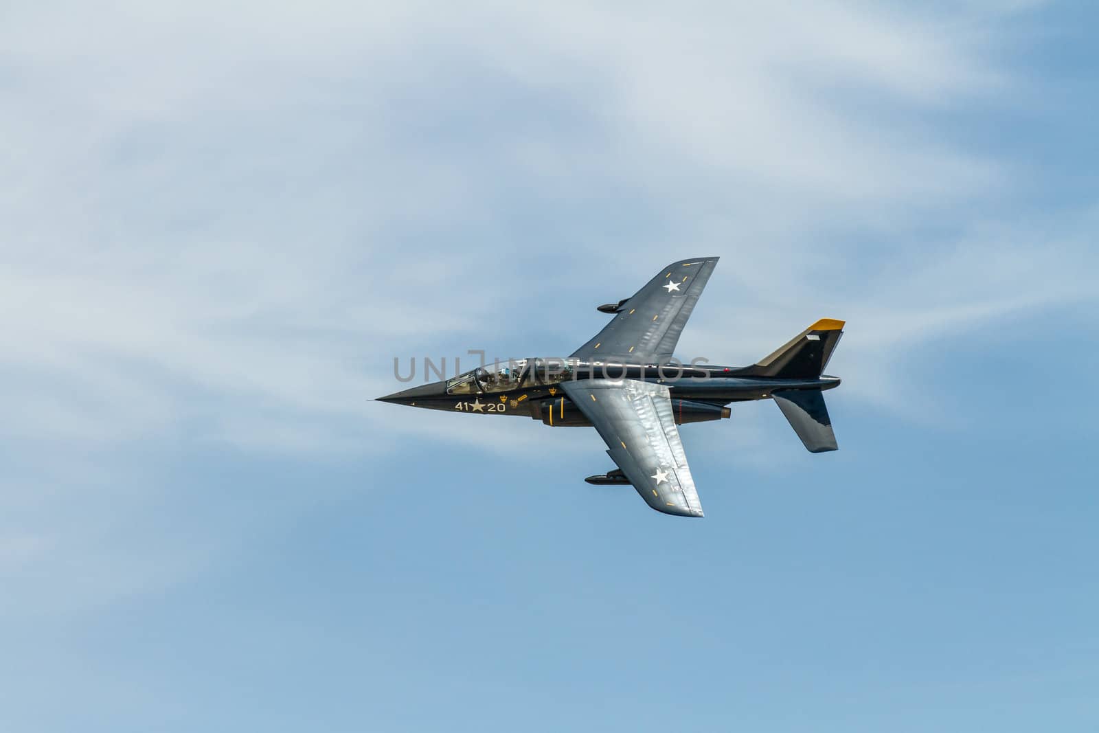 Alpha jet banked in flight against the blue sky