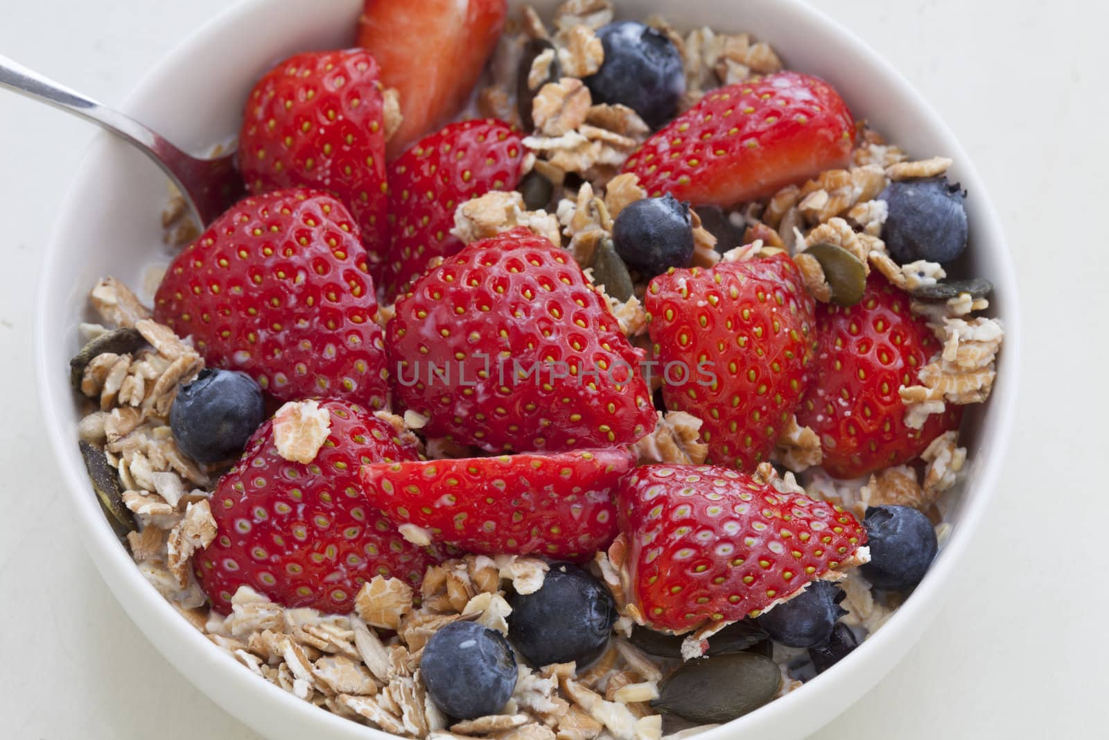 Fresh Muesli with strawberries, blueberries, pumpkin seeds, cereals and milk