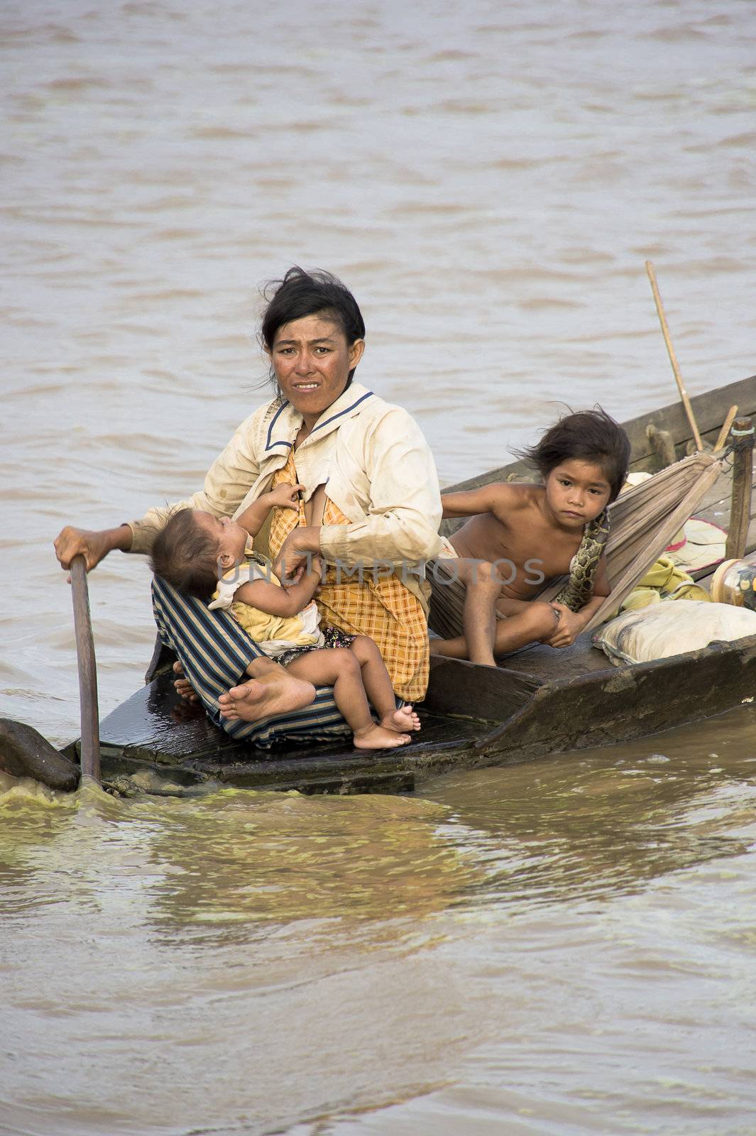 CAMBODIA – May 2012: Cambodian family in a rough wooden boat sailing in Tonle Sap Lake in Cambodia in May 2012.  Living conditions in the area are difficult - Cambodia
