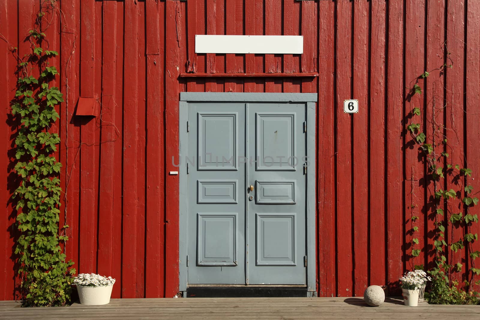 Grey Door on a house in Norway painted with typical Falun Red and white board with space for your own text
