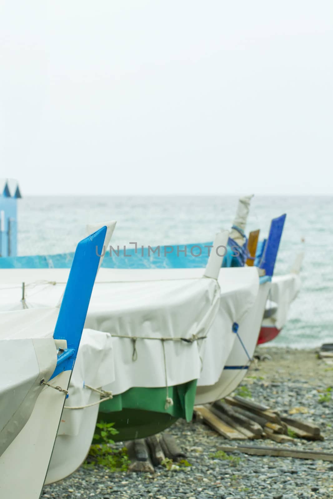 Row of boats stopped at beach with sea on the background