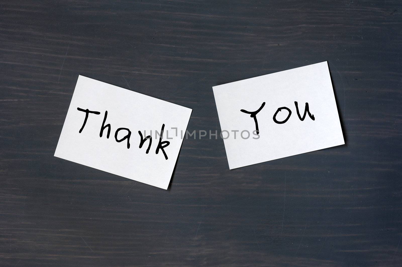 Thank you written on note sticked to a blackboard