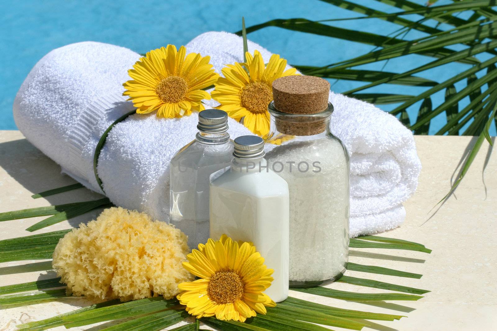 Spa products and white towels by the pool
