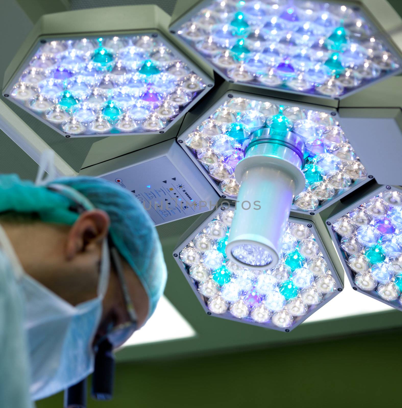 surgeon working under big diode lamp in operating room, focus on lamp