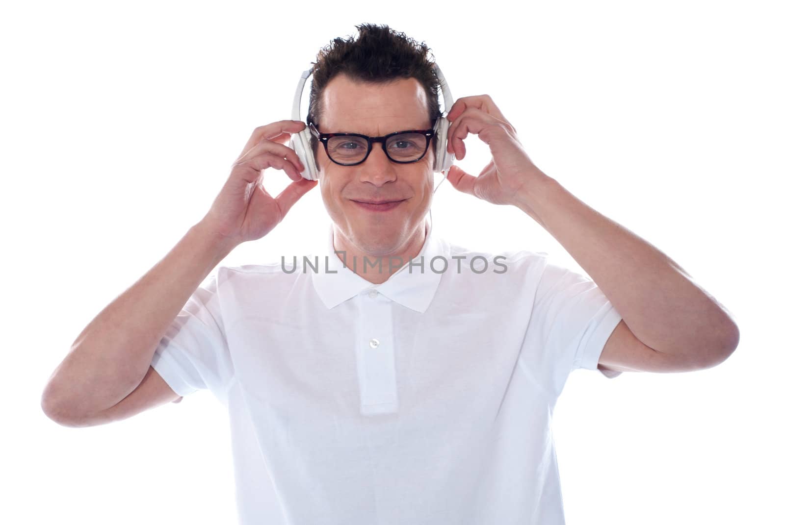 Handsome caucasian male enjoying music  holding his headphones