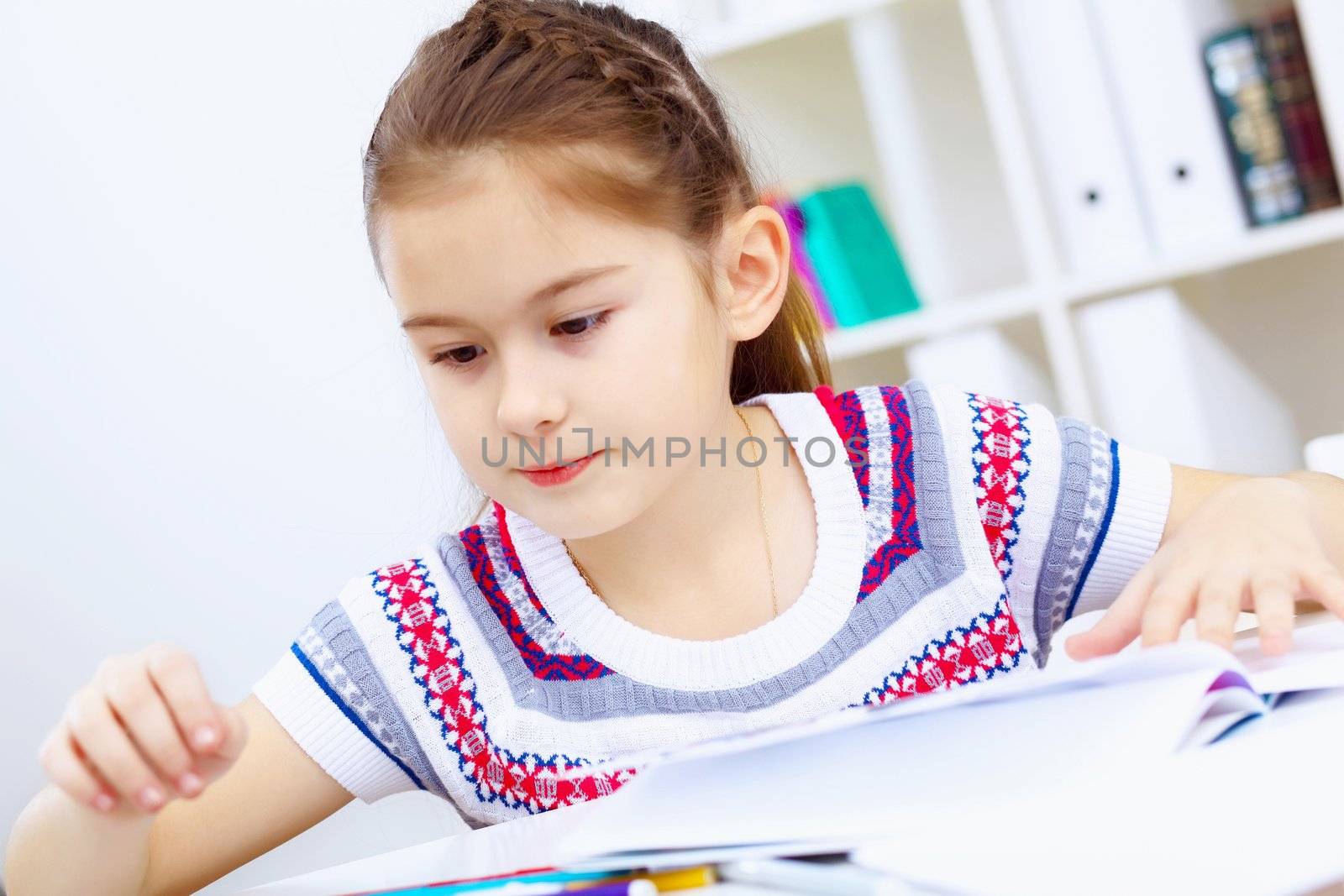 Little girl sitting and studying at home