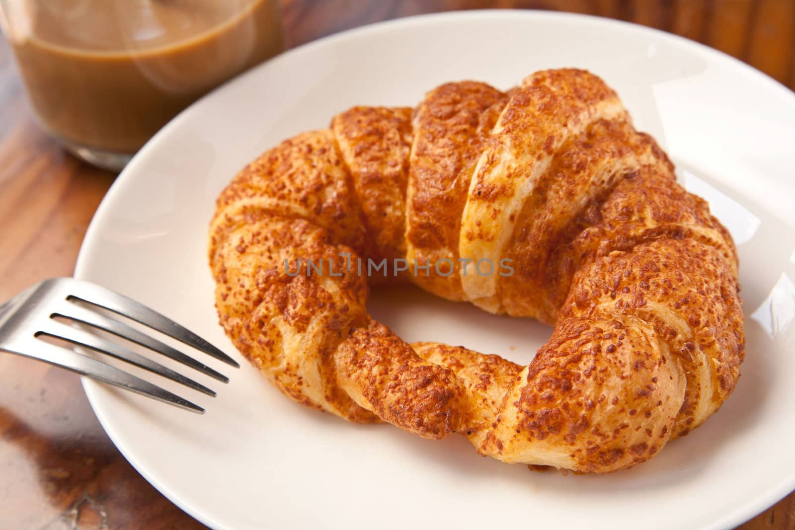 Couple eating breakfast croissant with coffee.