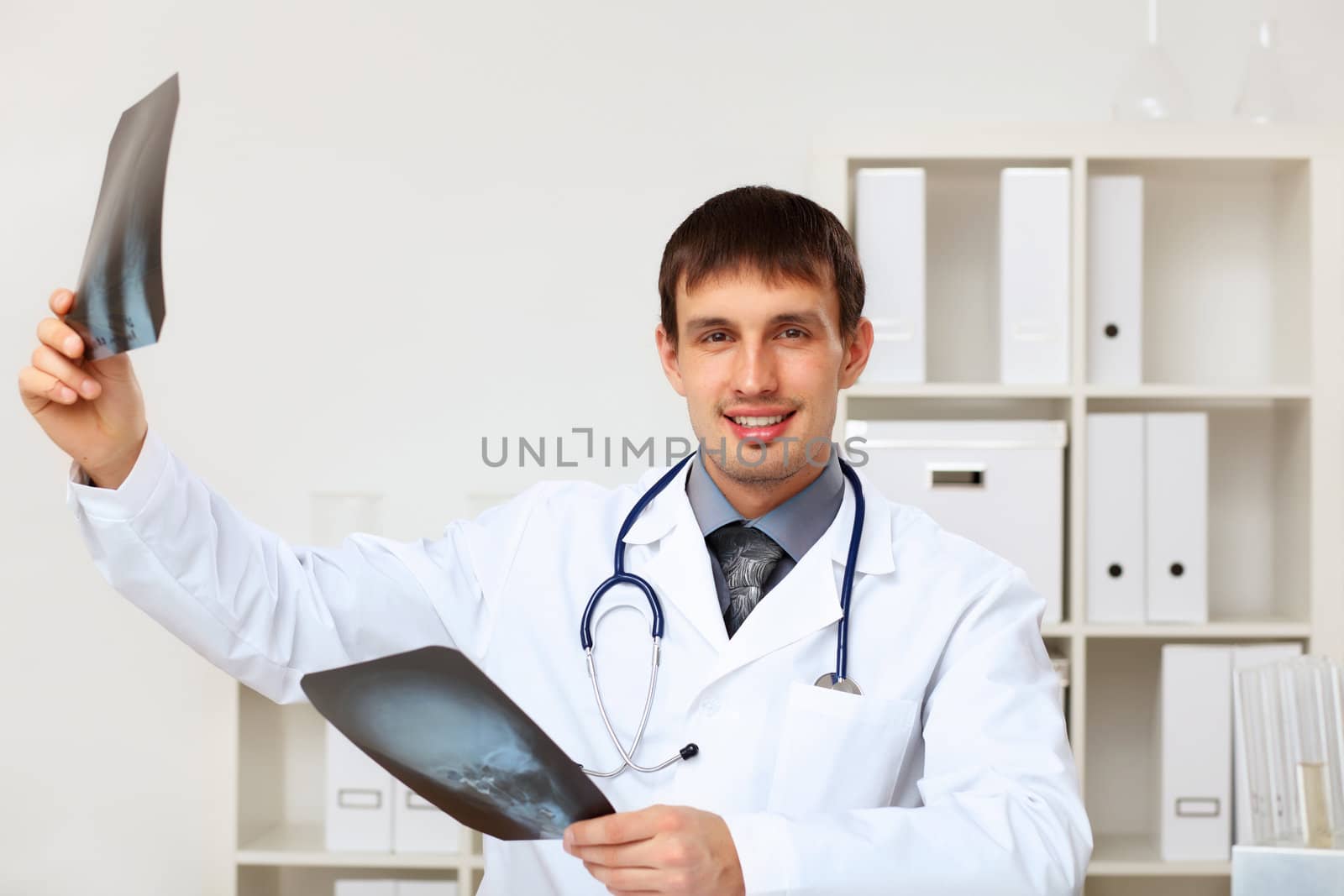 Young male doctor in white uniform at workplace