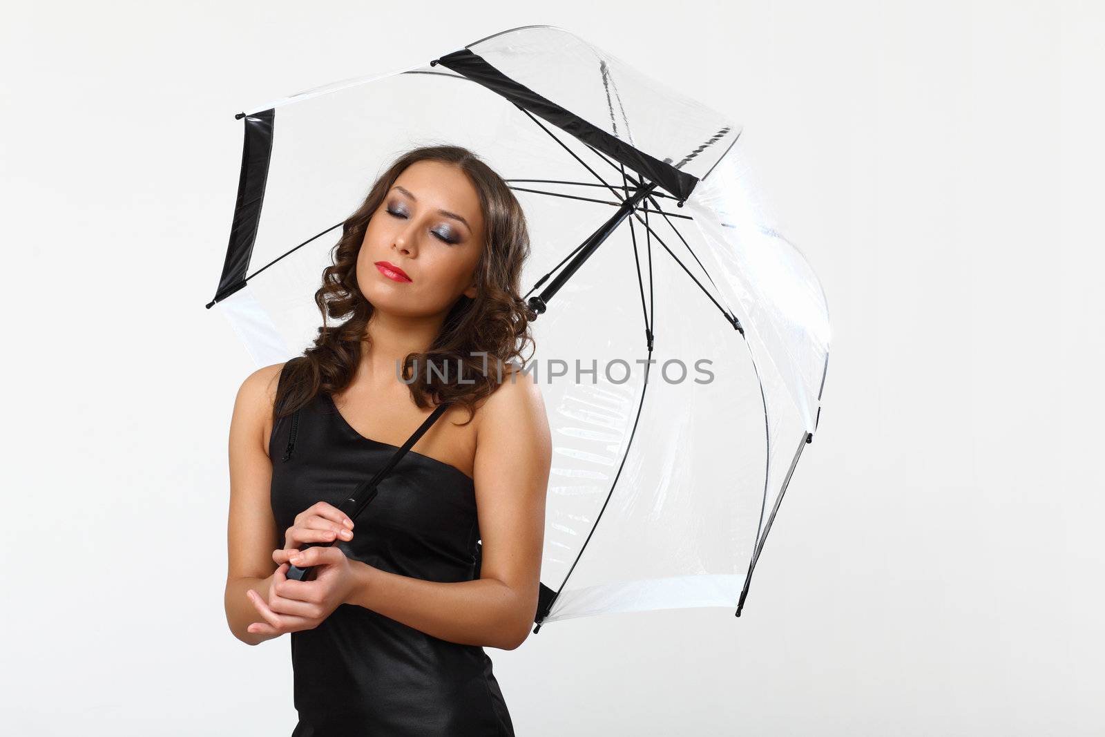 Portrait of young woman with umbrella in studio