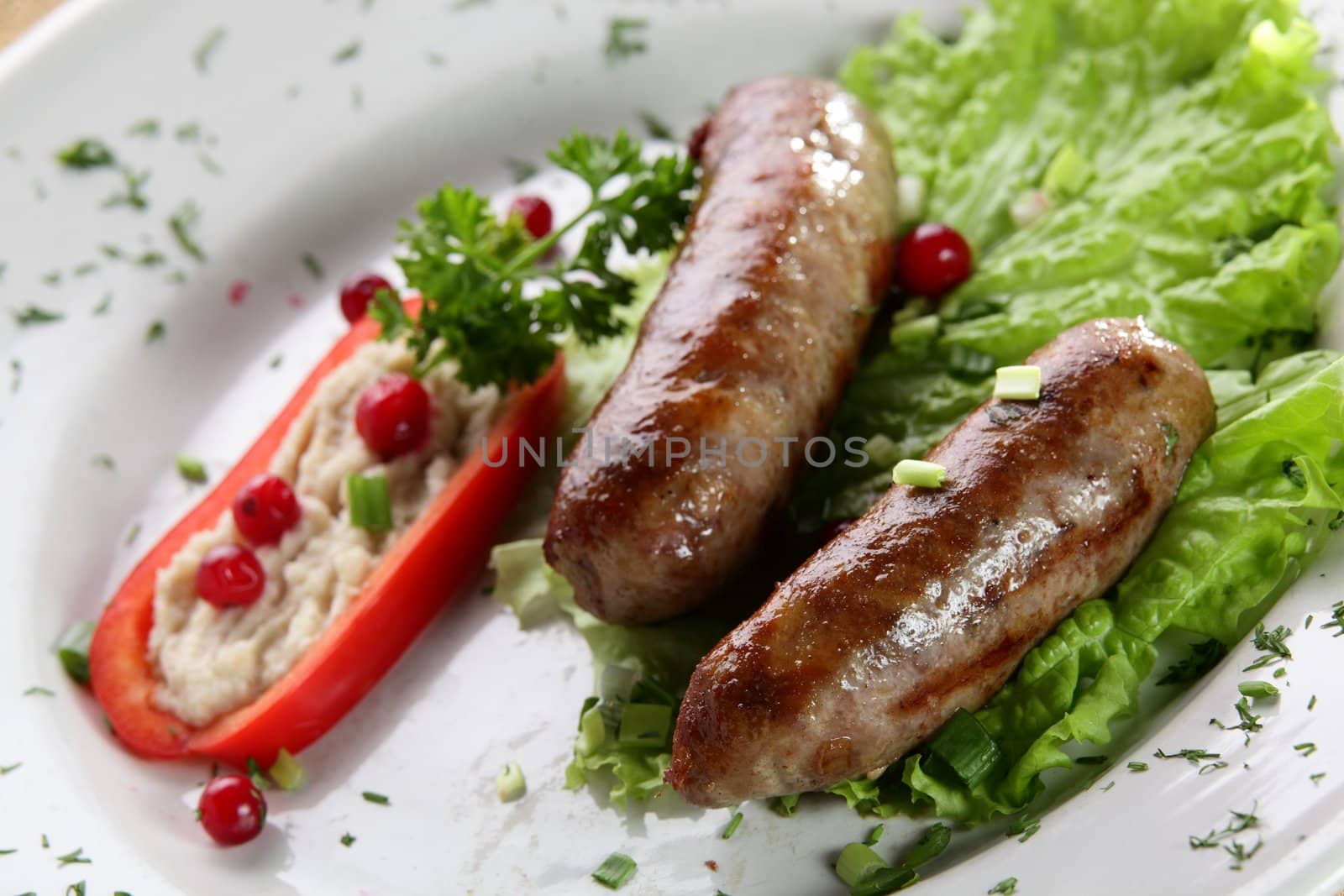 roasted sausages with pepper and berries in white pan