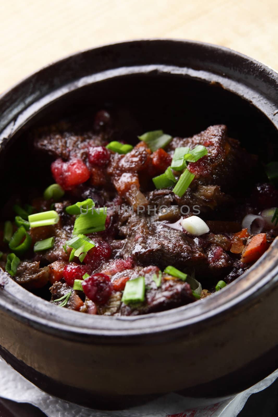 roated meat with onion and carrot on black pan