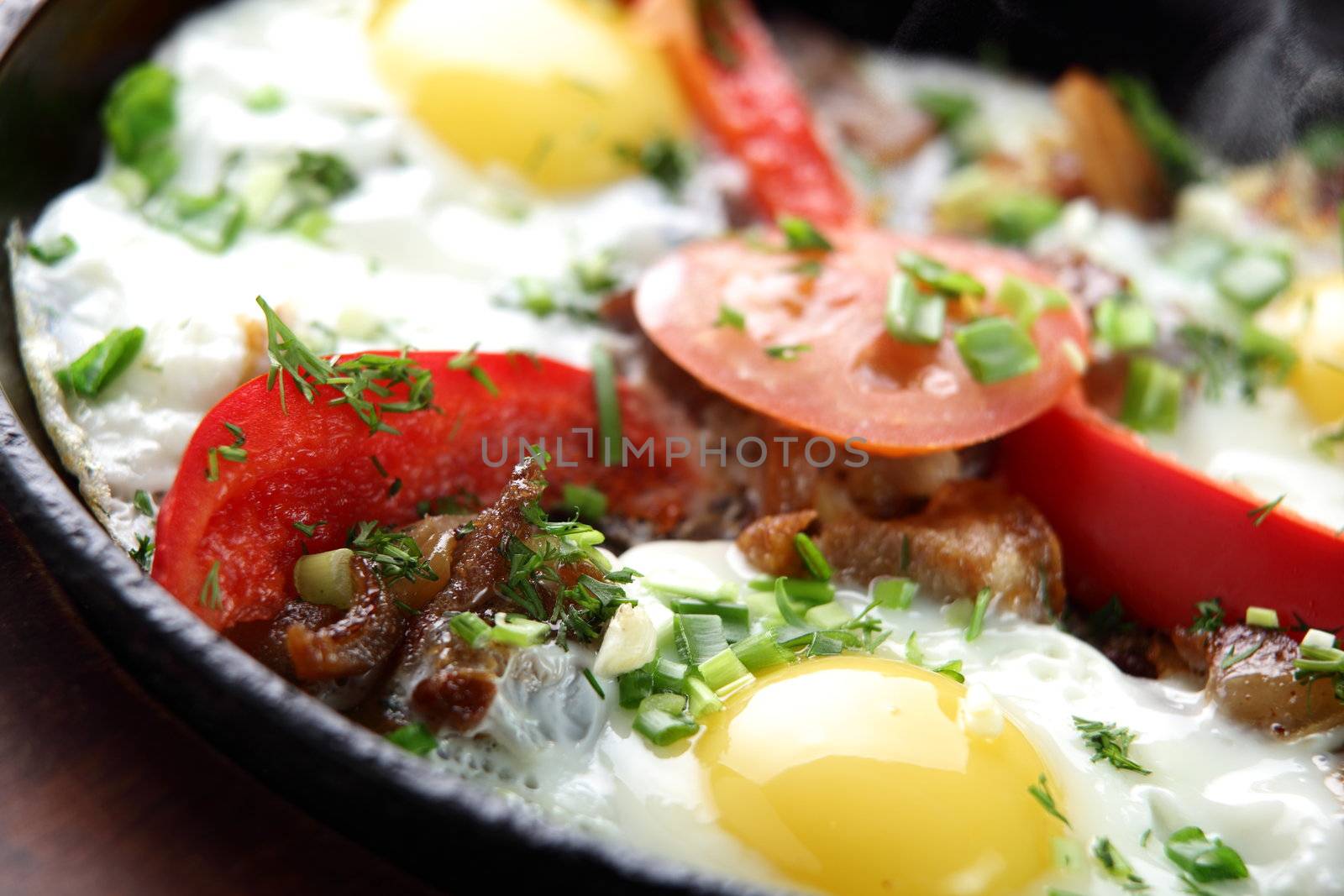 eggs with pepper and tomato on black pan