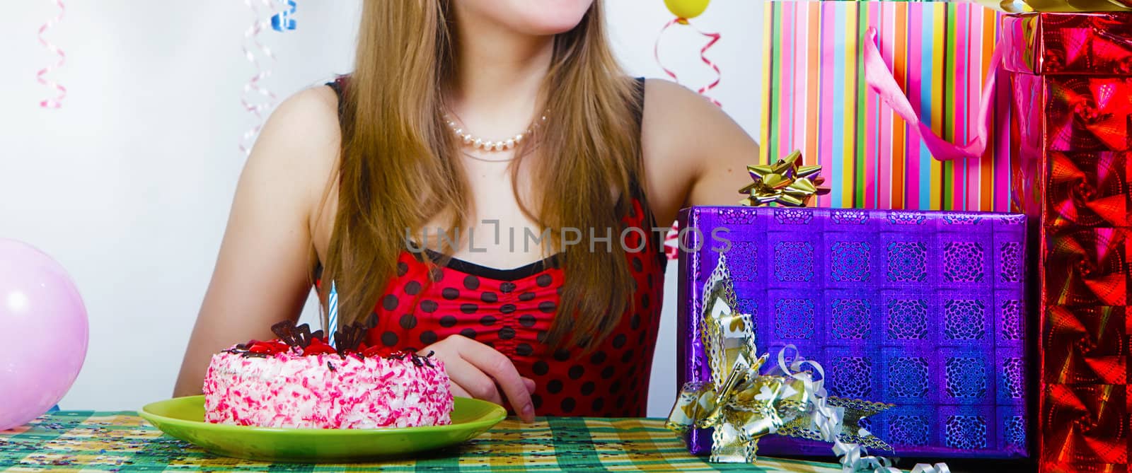 Birthday. Girl with cake and gifts on the holiday table