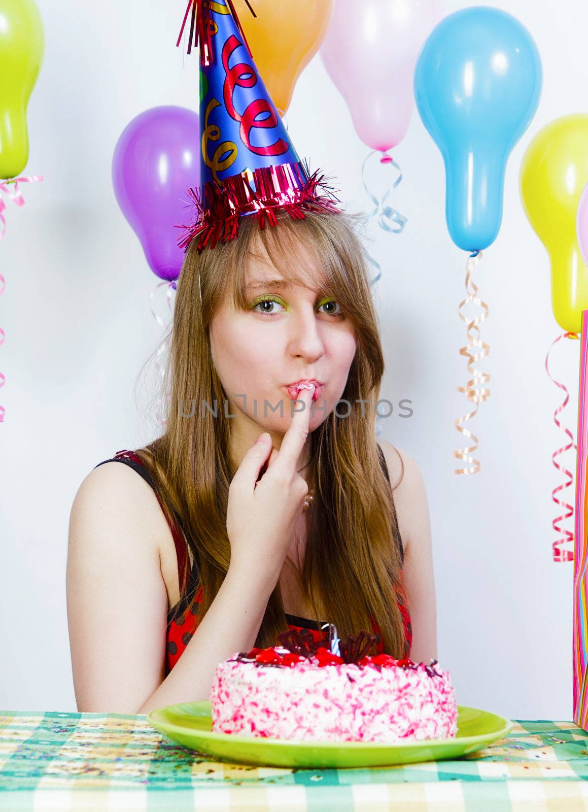 Birthday. A young attractive girl eating cake with your fingers