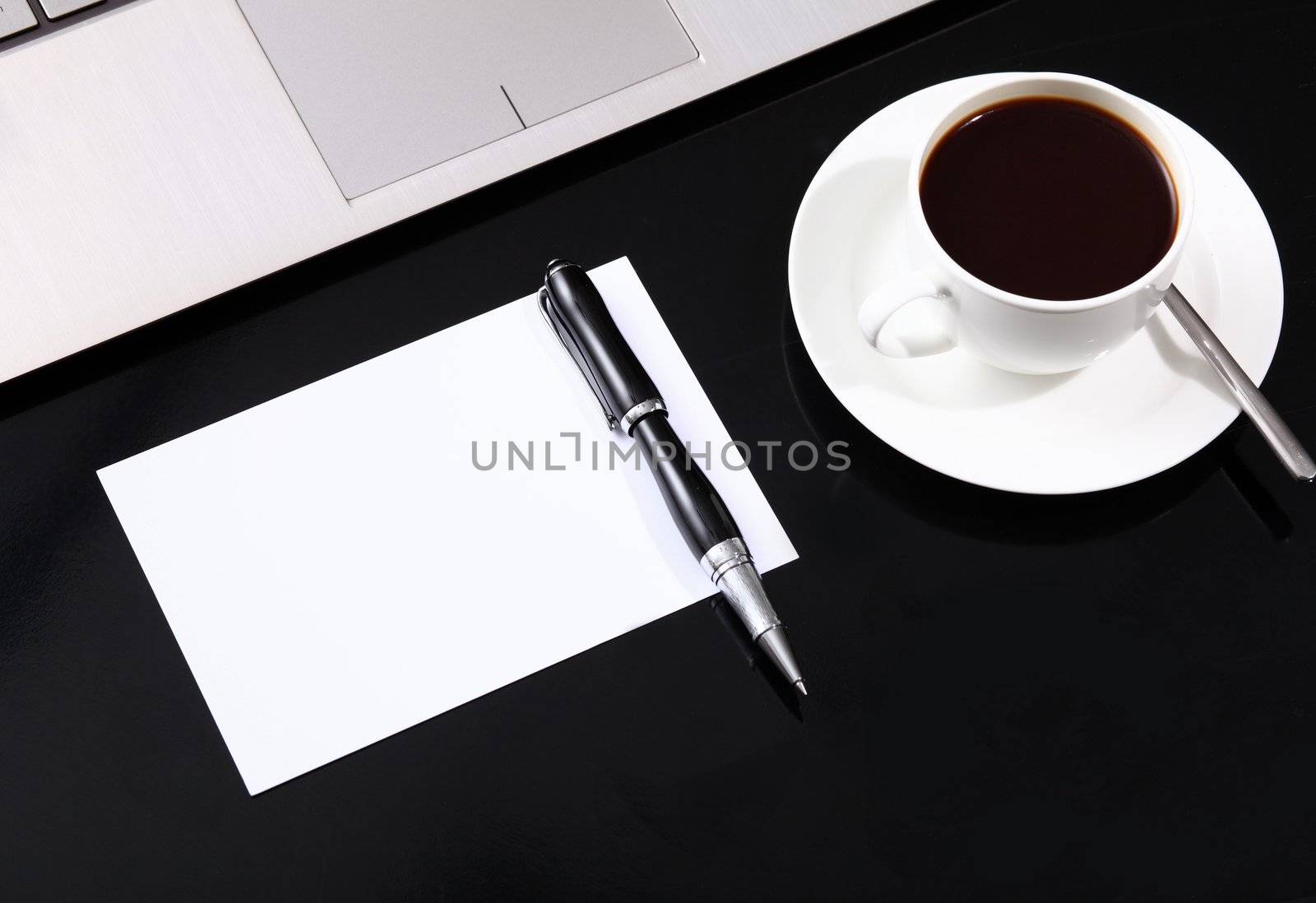 White cup with black coffee at business workplace