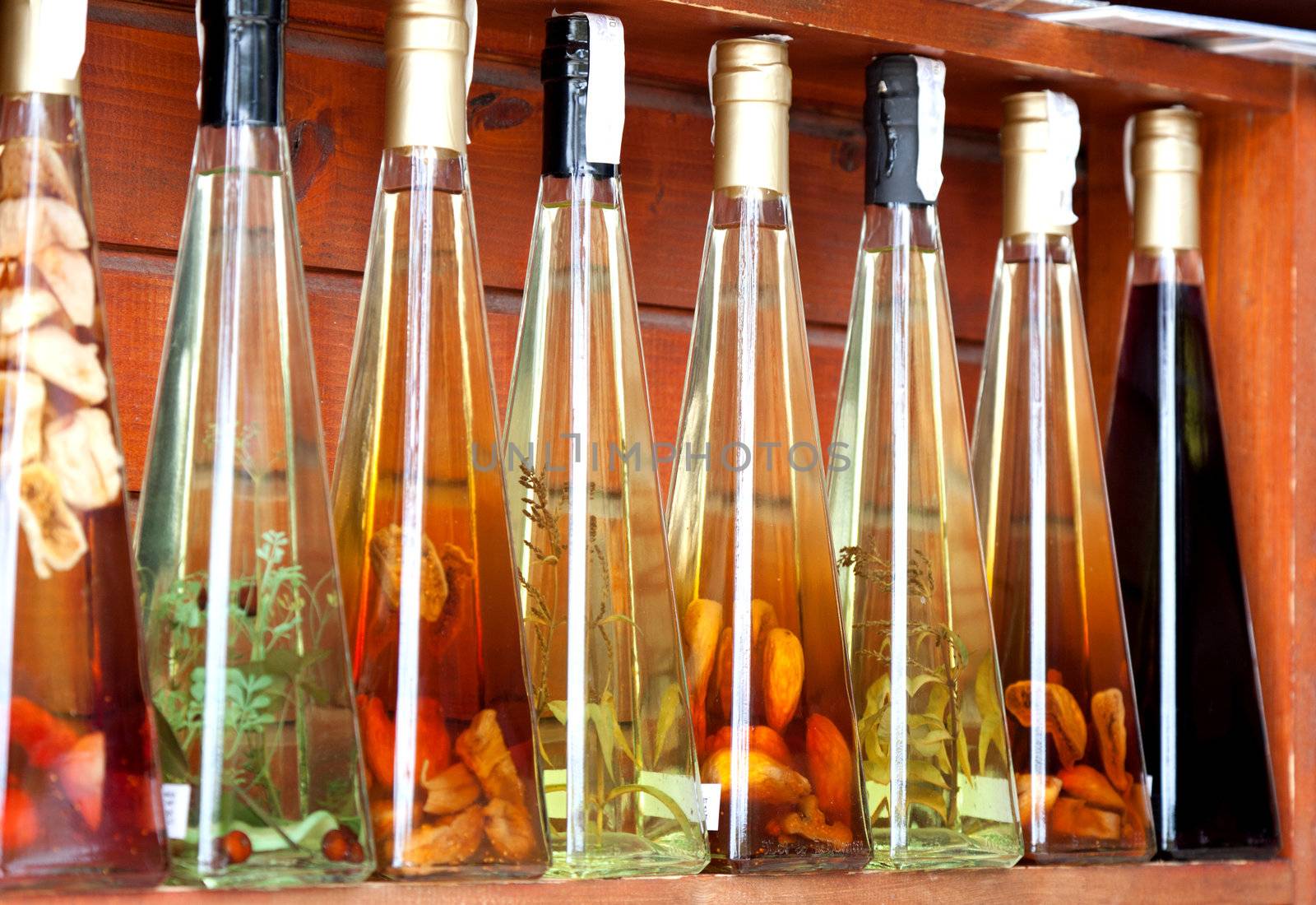 colorful liqueur and vinegar bottles on a market in croatia.