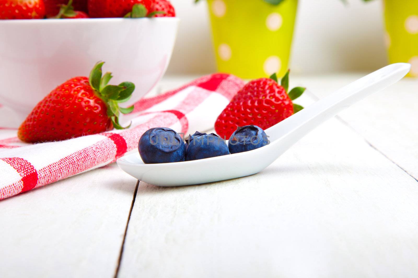 fresh blueberry in white porcelain spoon, wooden background