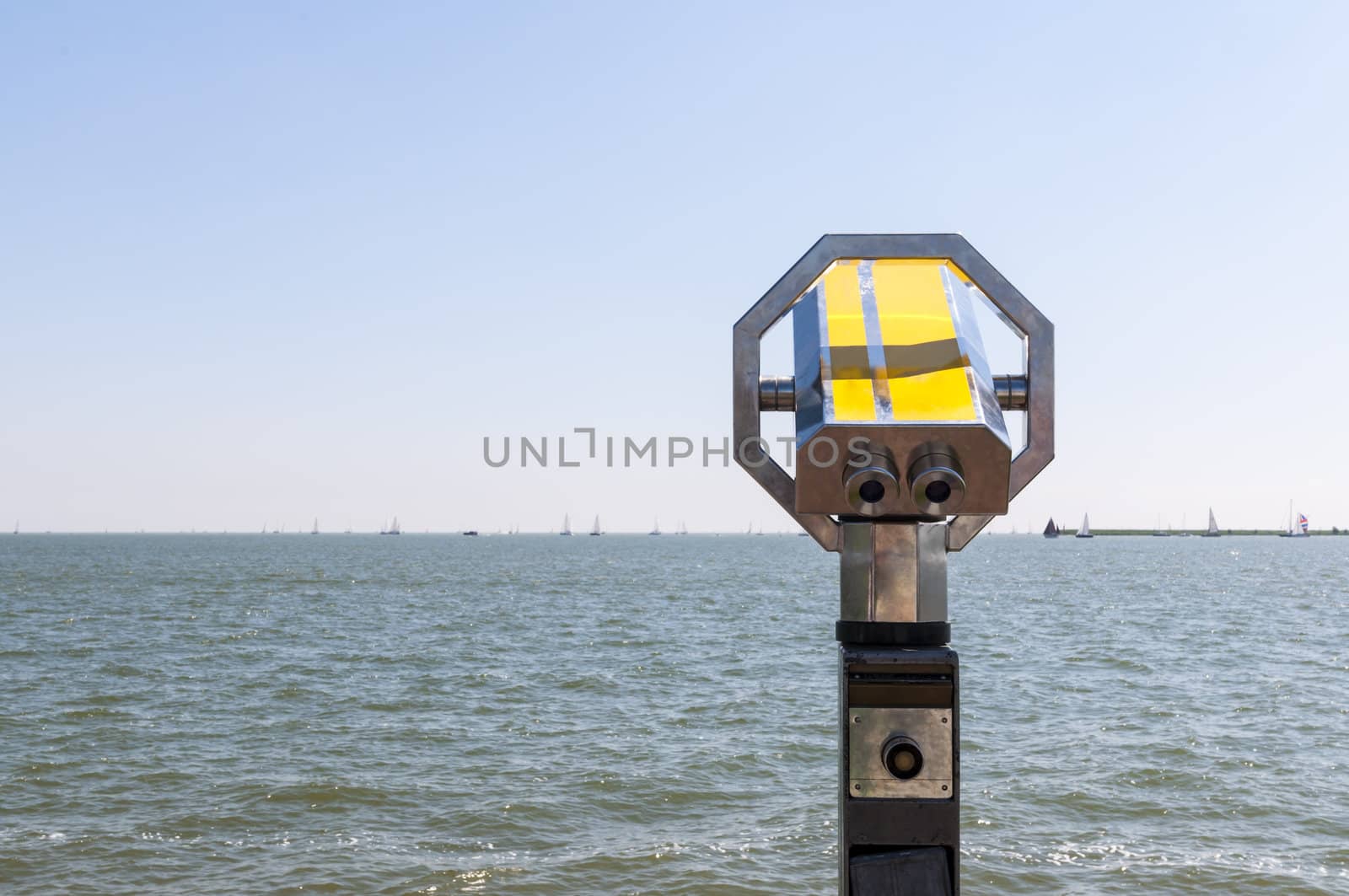 Pay binoculars with sea full of sails in the background.