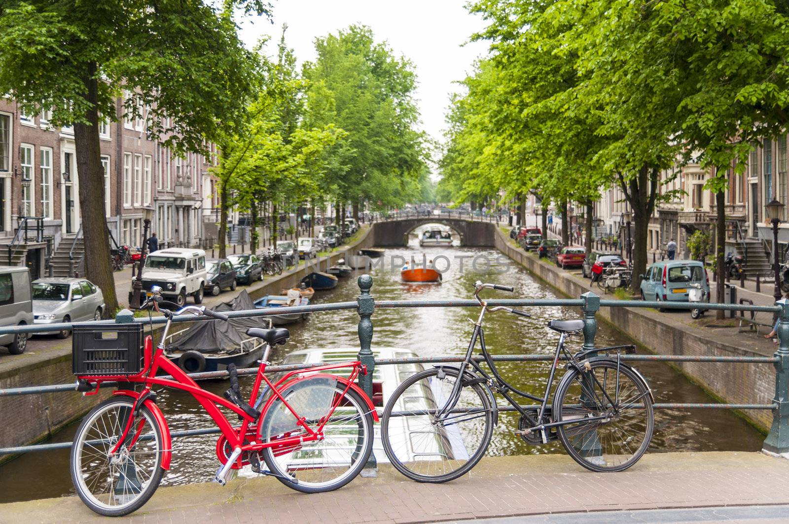 Detail of bicycles locked on top of bridge in Amsterdam, Holland, with traditional canal in the background.
