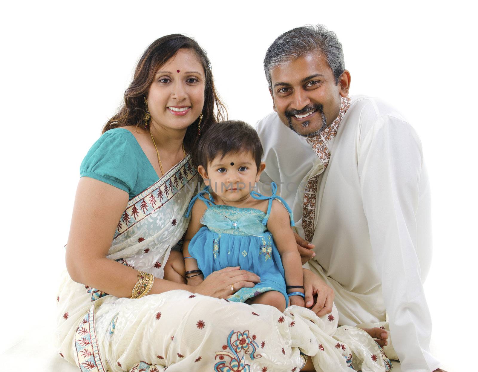 Traditional Indian family with one child sitting on white background