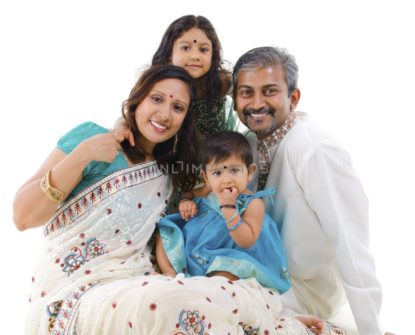 Happy Indian family with two children in traditional costume sitting on white background