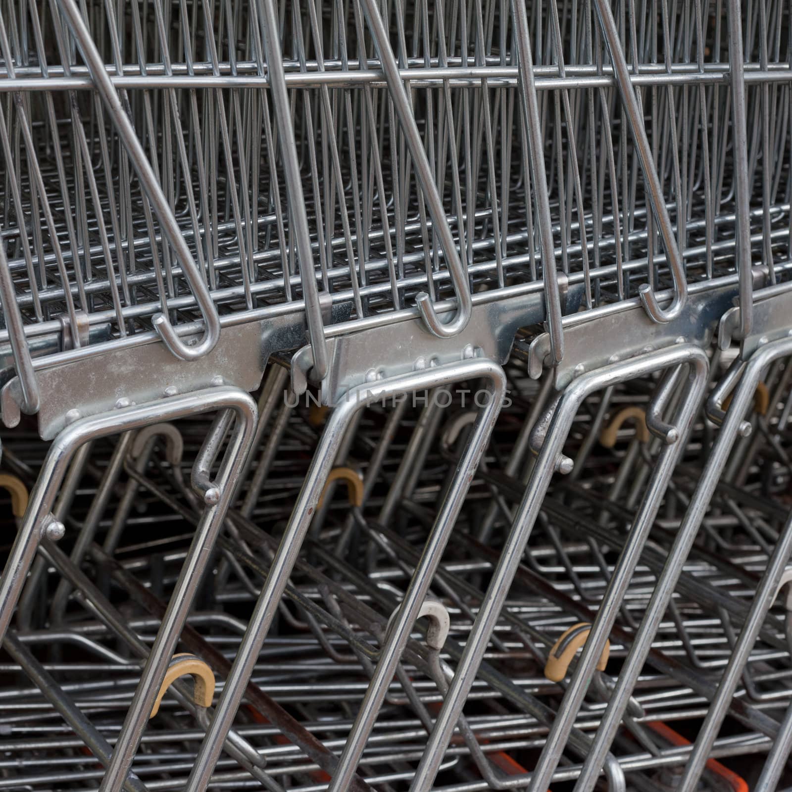 Detail of shiny metal shopping carts stacked in a row.