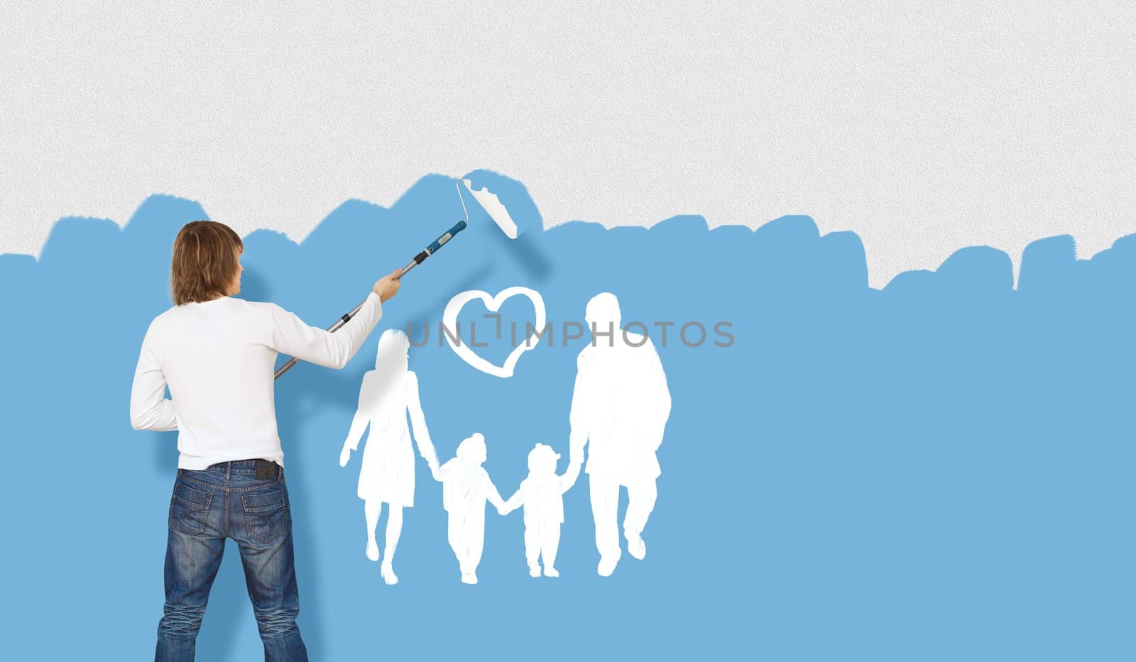 Young man with a paintbrush and family picture on the wall