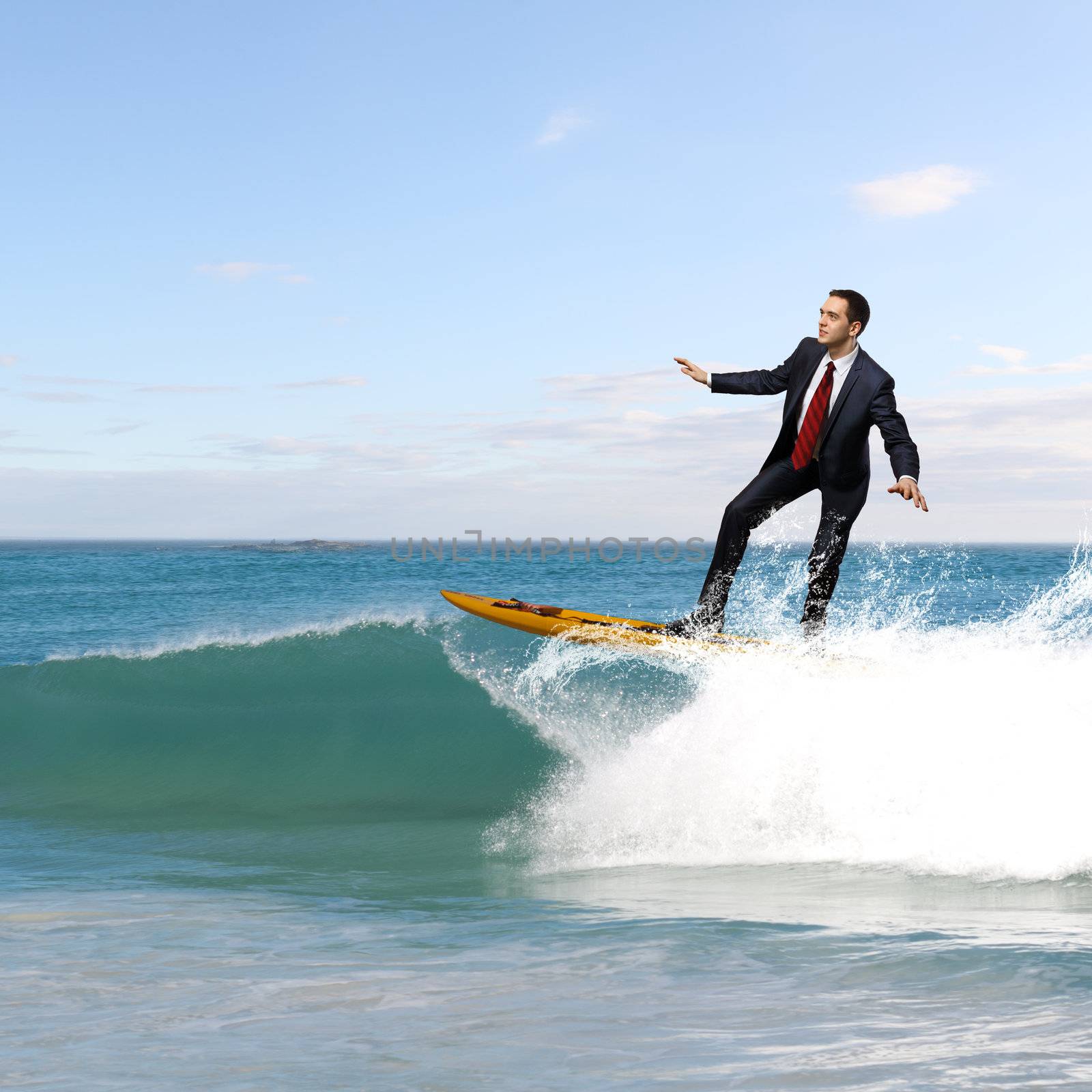 Image of young business person surfing on the waves of the ocean