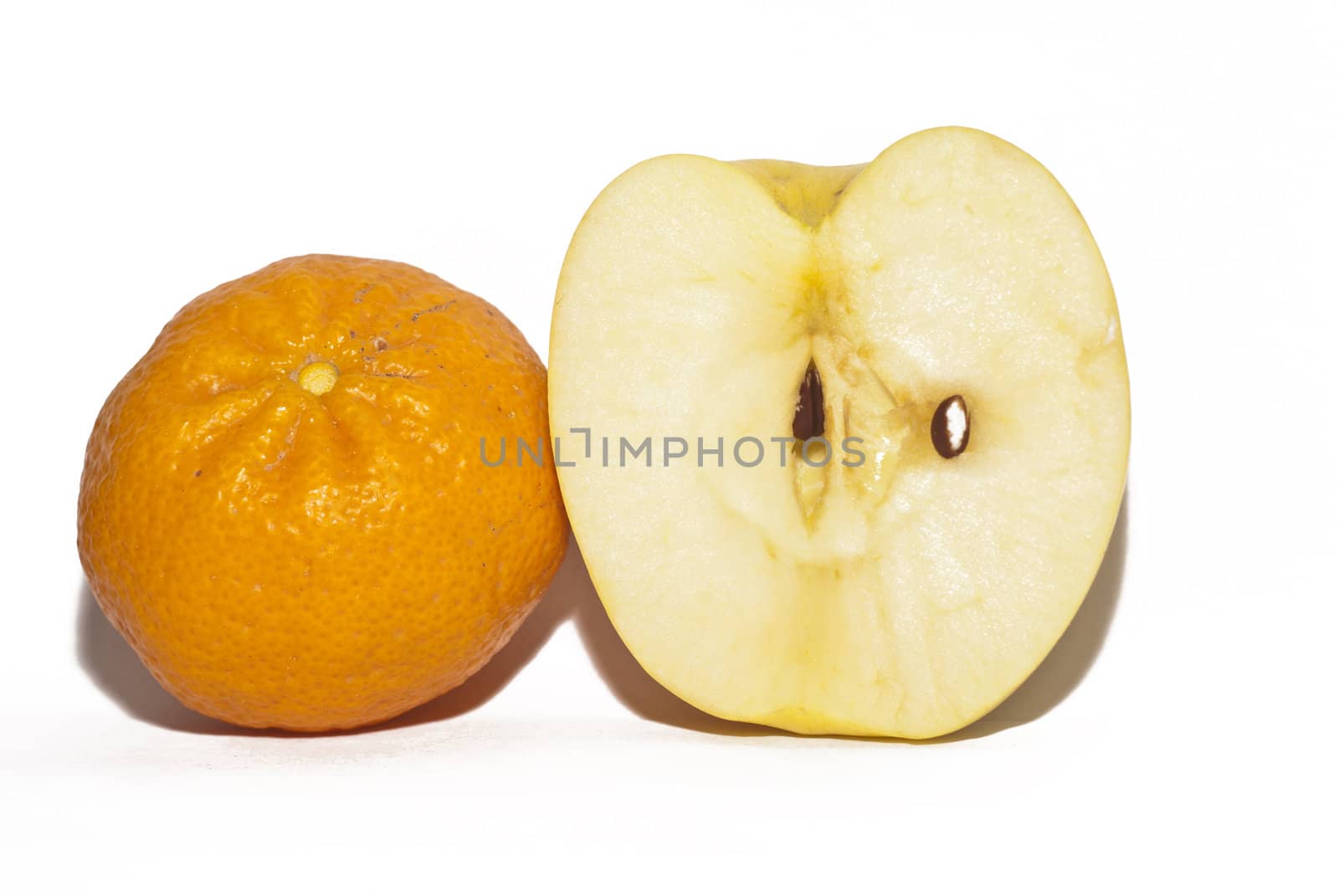 half apple and tangerine isolated on white background