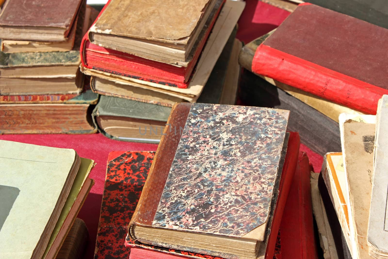 Piles of old damaged books on a table.