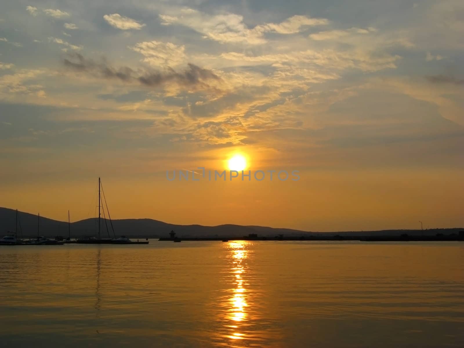 Golden Sunset in calm colorful water yacht marina port.