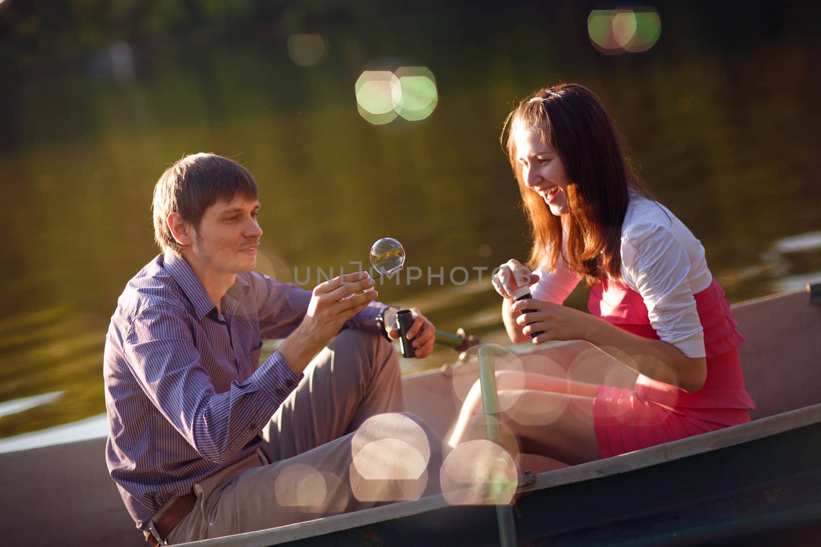 couple in a boat with bubble blowers by vsurkov