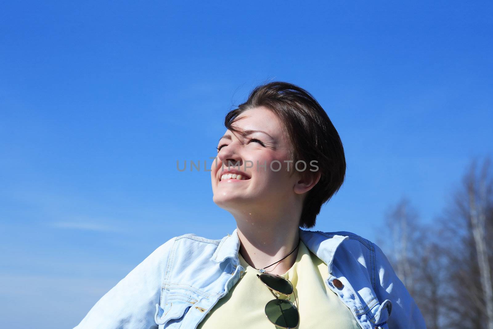 Portrait of smiling beautiful young girl looking to the blue sky