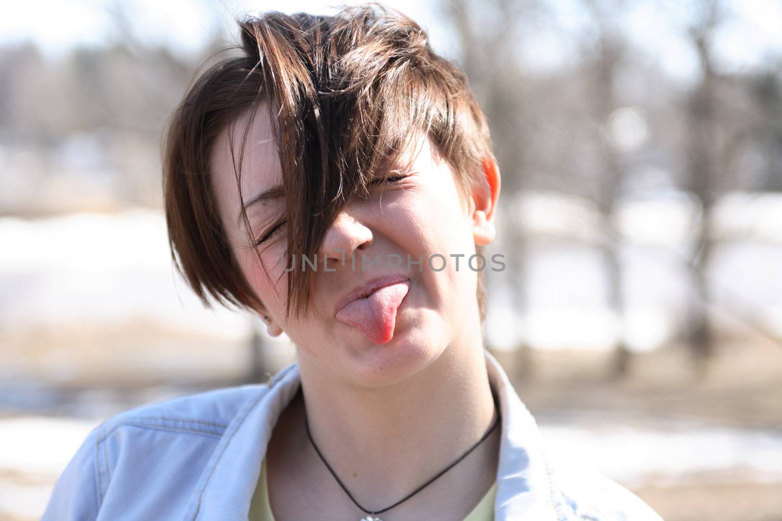 Closeup portrait of beautiful young girl  to stick her tongue out
