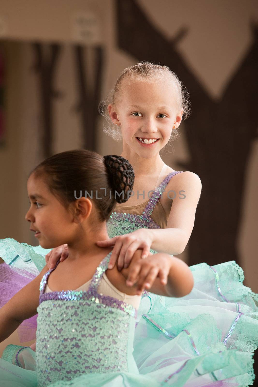 Cute child ballet student helps her partner during rehearsal
