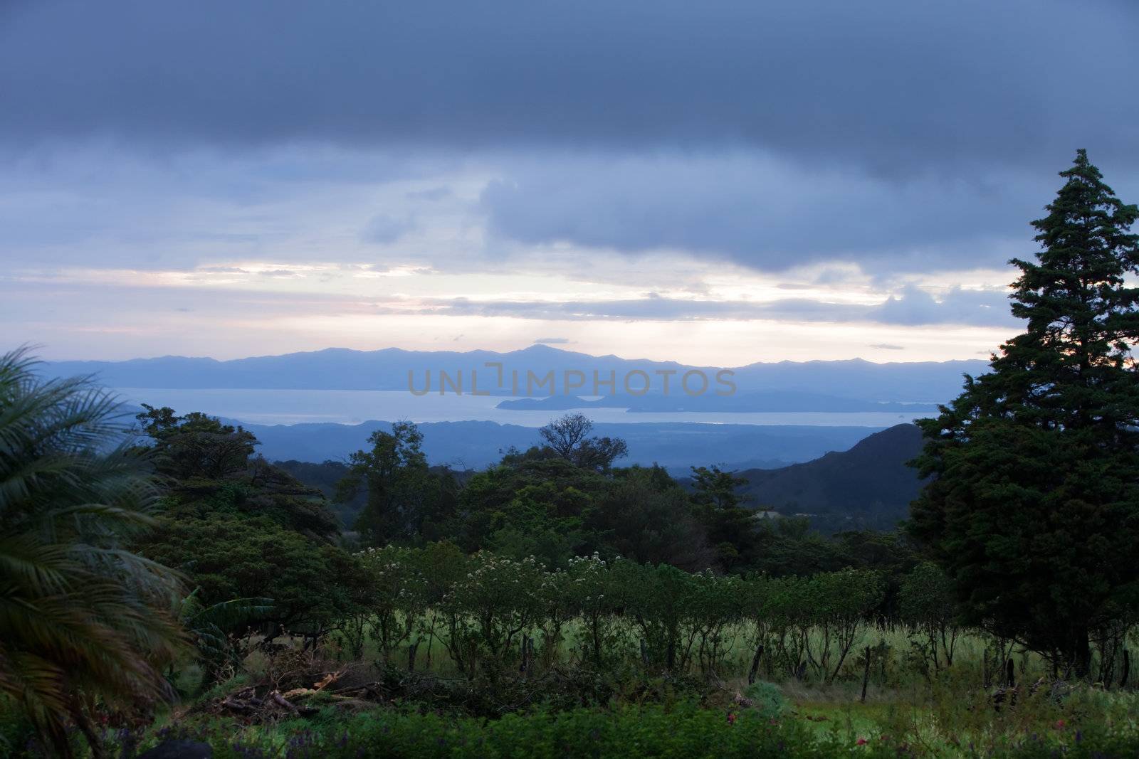 Costa Rican meadow scene with sunlight mountains and trees