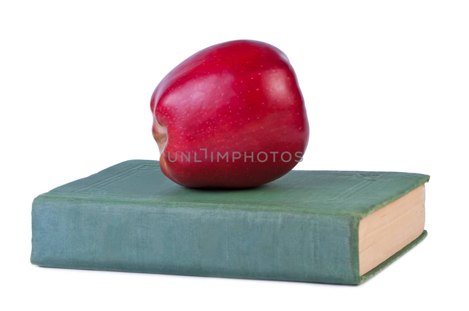 Red apple on old book, isolated on white background.